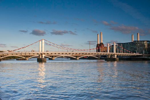 The River Thames with the Grosvenor Rail Bridge and Battersea Power Station in the background with blue sky and white clouds