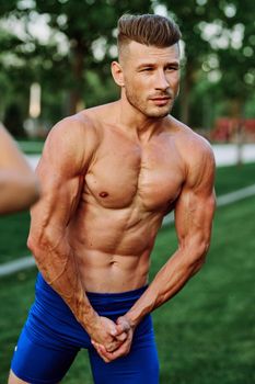 man with pumped up muscular body outdoors health workout. High quality photo