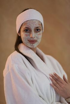 Spa Woman applying Facial Mask  Beauty Treatments  Close up portrait of beautiful girl with a towel on her head applying facial mask