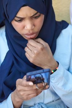 african  business woman using smart phone wearing traditional islamic clothes