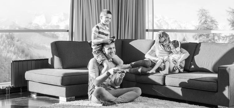 Happy family. Father, mother and children playing a video game Father and son playing video games together on the floor