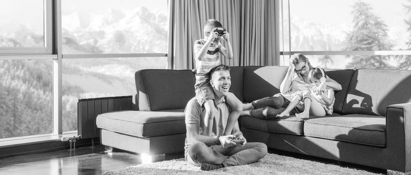 Happy family. Father, mother and children playing a video game Father and son playing video games together on the floor