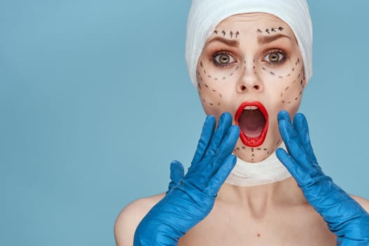 beautiful woman posing in blue gloves red lips surgery facial rejuvenation isolated background. High quality photo
