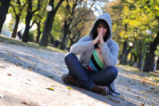 Cute young woman sitting outdoors in nature