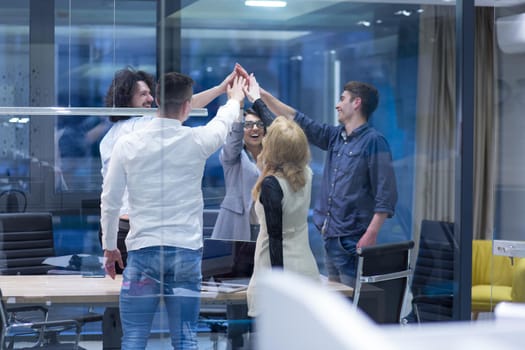 Group of young business people looking happy while celebrating success at their working places in startup office