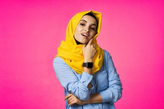 muslim woman with smart watch technology posing pink background. High quality photo