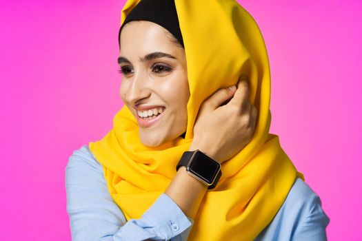 muslim woman with smart watch technology posing pink background. High quality photo