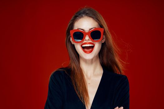 pretty woman wearing sunglasses fashion posing hairstyle red background. High quality photo