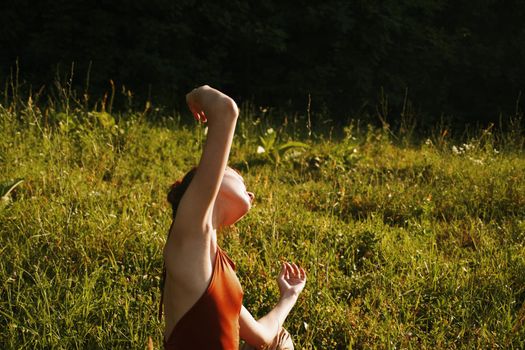 woman in summer sitting on the grass outdoors meditation freedom. High quality photo