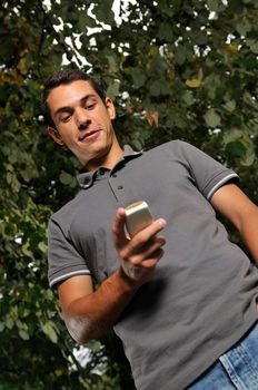 young happy  casual man talking on cellphone and writing sms message