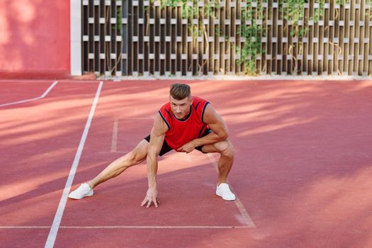 athletic man in red jersey on the sports ground exercise. High quality photo