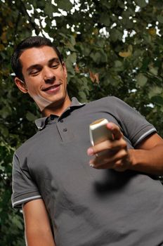 young happy  casual man talking on cellphone and writing sms message