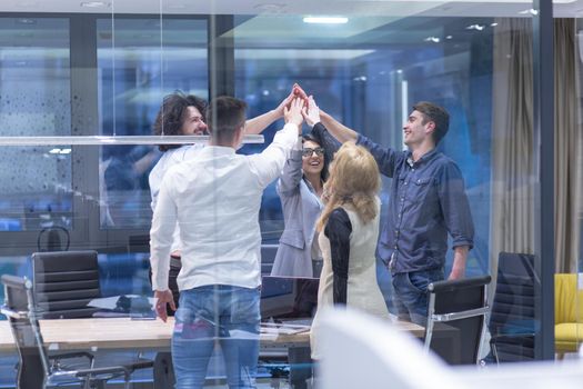 Group of young business people looking happy while celebrating success at their working places in startup office