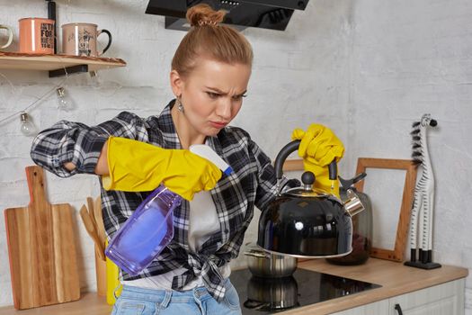 Domestic service and housekeeping concept, happy blonde lady cleaning kitchen kettle, close-up of hands in rubber gloves holding spray