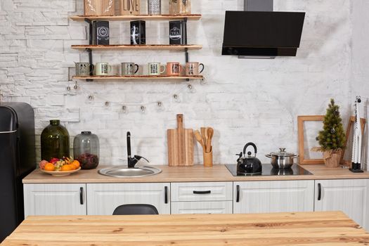 Empty wooden table, sink and stove in kitchen interior. Copy space