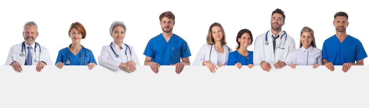 Many confident multiethnic medical doctors team holding big blank billboard isolated on white background, copy space for text