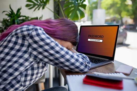 Side view of a young pink hair woman sitting in cafe, hand typing laptop computer with password login on screen. Cyber security concept. Woman forgot the password from the laptop