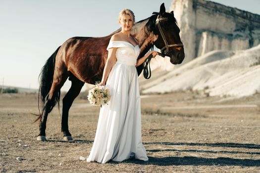 Portrait of a beautiful bride standing with horse