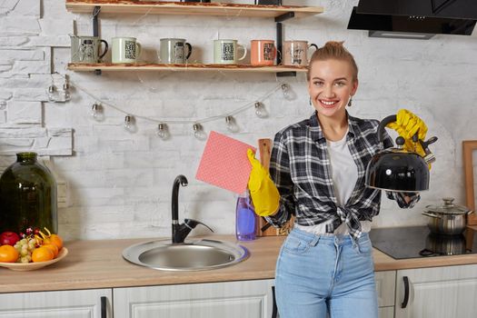 Domestic service and housekeeping concept, happy blonde lady cleaning kitchen kettle, close-up of hands in rubber gloves holding spray