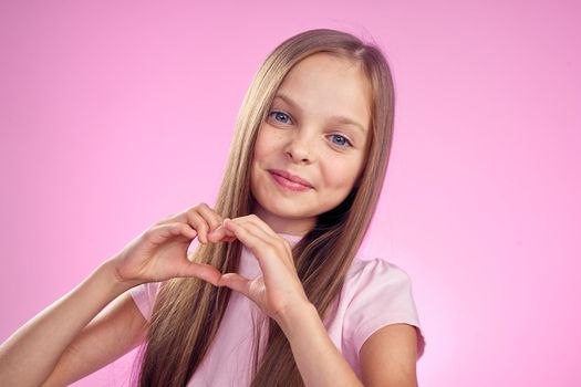 cute girl with long hair on pink background lifestyle childhood. High quality photo