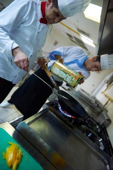 chef in hotel kitchen prepare vegetable  food with fire