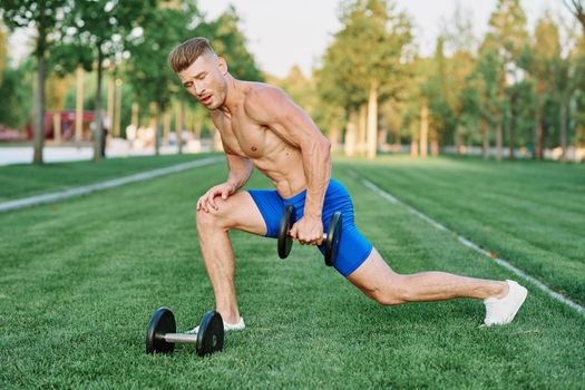 sporty man with pumped up body in park workout exercise. High quality photo