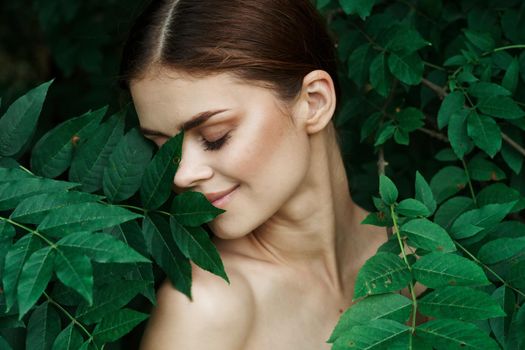 portrait of a woman skin care bare shoulders green leaves nature Lifestyle. High quality photo