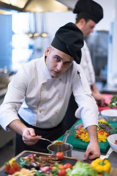 Chef finishing steak meat plate with Finally dish dressing and almost ready to serve at the table