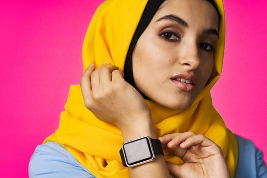 muslim woman with smart watch technology posing pink background. High quality photo