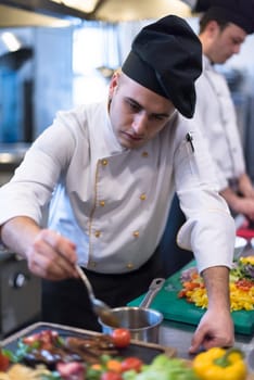 Chef finishing steak meat plate with Finally dish dressing and almost ready to serve at the table