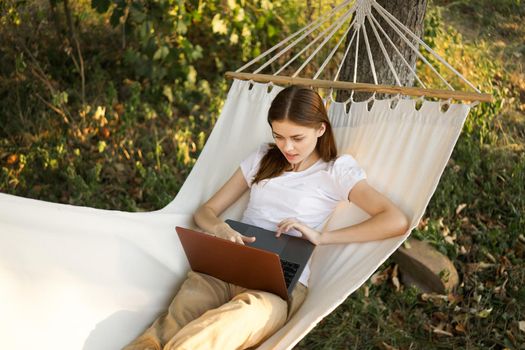 woman lies on a hammock with laptop travel vacation internet. High quality photo
