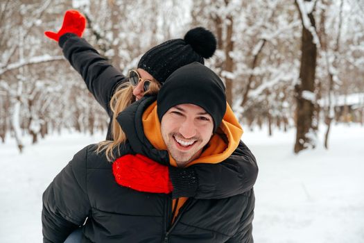 Happy couple hugging and smiling outdoors in snowy park close up
