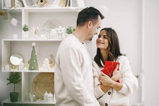 Young cheerful couple in love with present for Christmas, portrait