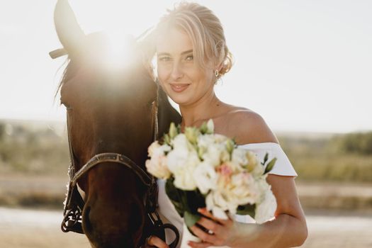 Portrait of a beautiful bride standing with horse