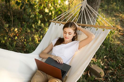 woman lies on a hammock with laptop travel vacation internet. High quality photo