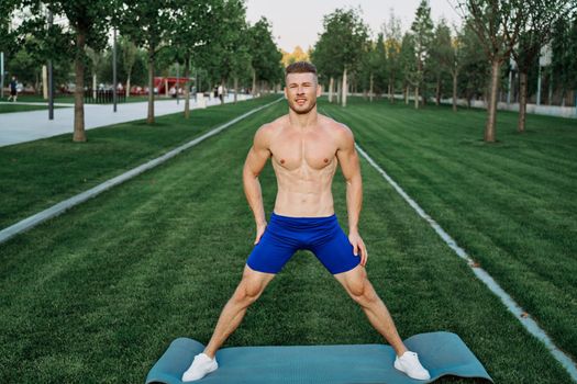 sporty man in shorts in the park working out outdoors. High quality photo