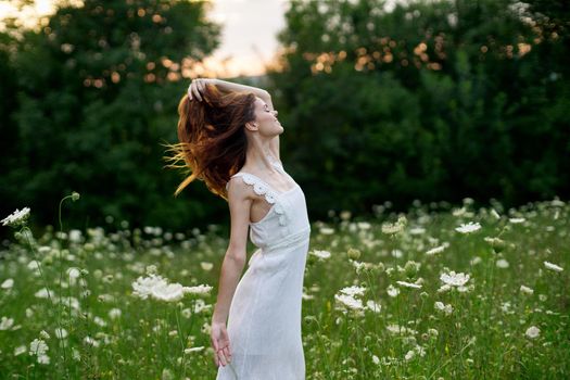 Woman in white dress in a field flowers sun nature freedom. High quality photo