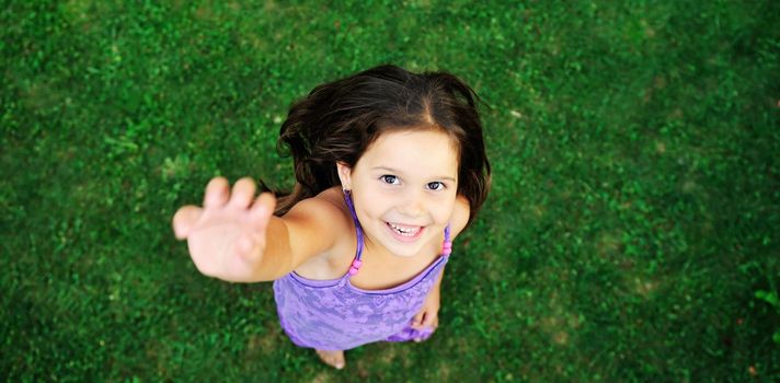 happy young girl children relax lie and have fun on grass with flower