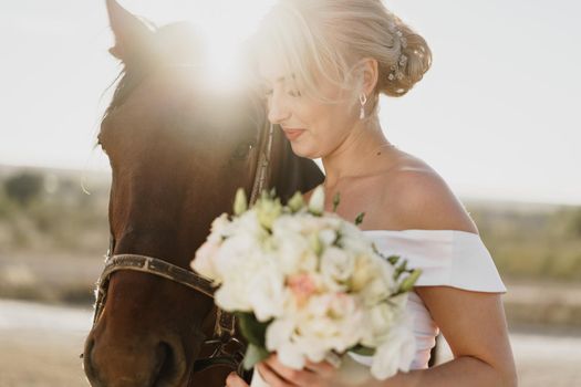 Portrait of a beautiful bride standing with horse