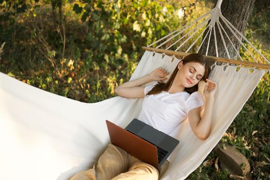 woman lies on a hammock with laptop travel vacation internet. High quality photo