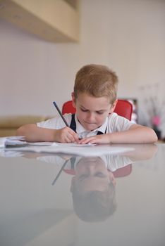 young mom woman doing home work with elementary school grade boy at home in kitchen