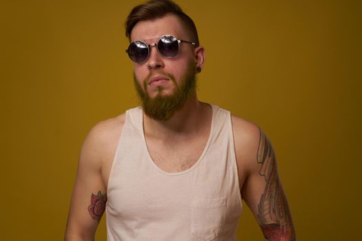 man in a white t-shirt tattoos on his arms fashion glasses modern style. High quality photo