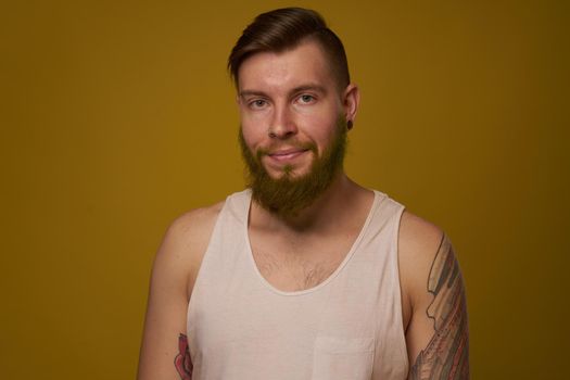 Cheerful bearded man in a white T-shirt with hooligan tattoos on his arms. High quality photo