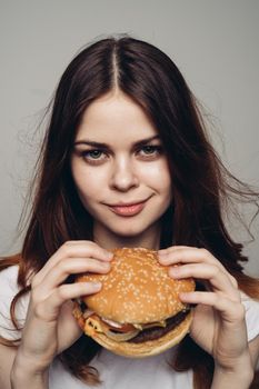 woman with a hamburger in her hands a snack fast food close-up. High quality photo