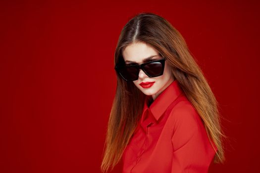 beautiful woman wearing sunglasses red shirt makeup isolated background. High quality photo