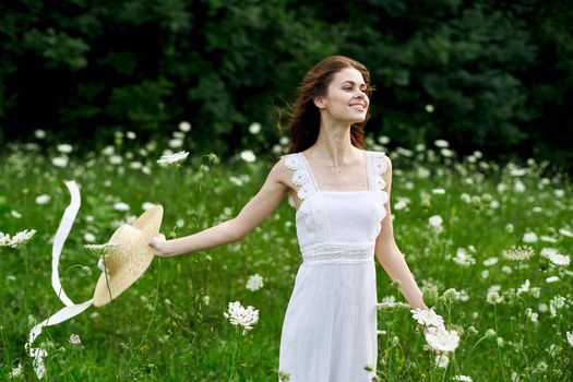 Woman in white dress hat nature field flowers. High quality photo