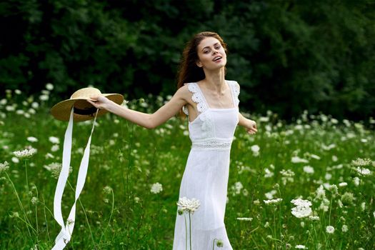 Woman in white dress hat nature field flowers. High quality photo