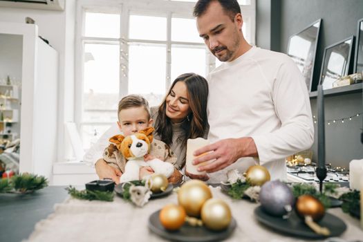 A portrait of happy family in the kitchen decorated for Christmas holidays