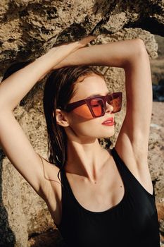 pretty woman in black swimsuit sunglasses posing sun. High quality photo