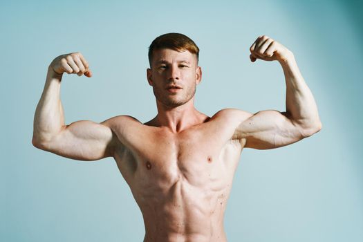 bodybuilder with muscular body posing press blue background. High quality photo